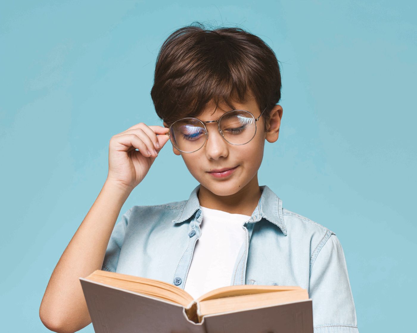 Boy in glasses reading a book