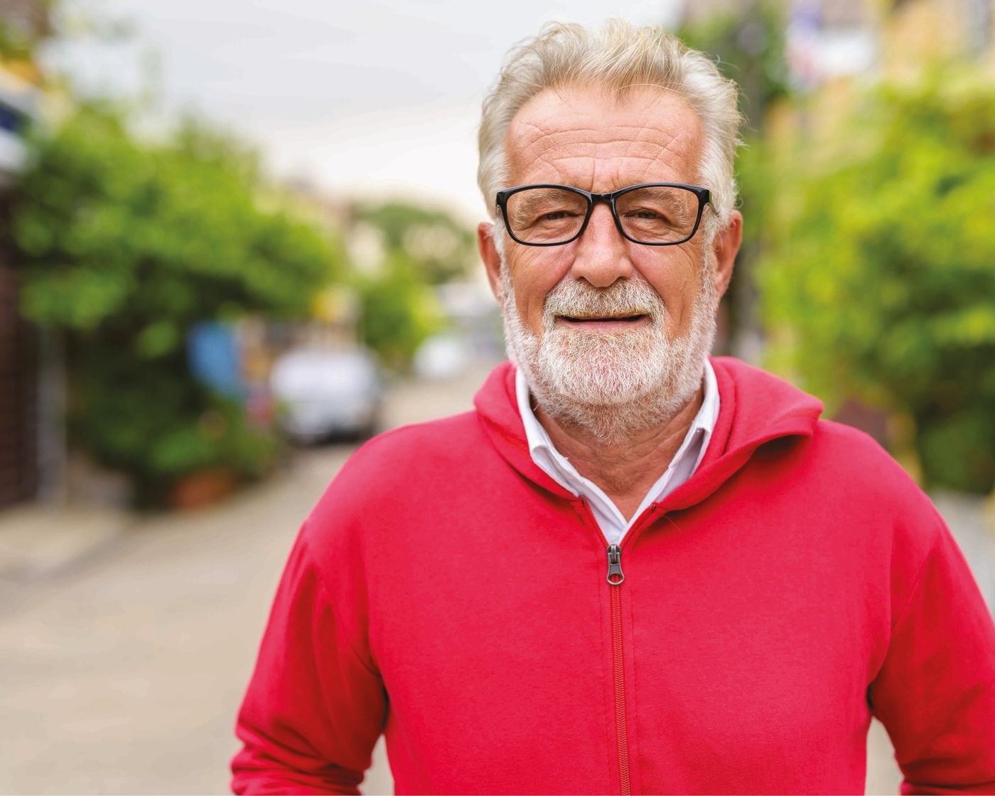 Smiling older man wearing single-vision eyeglasses outdoors