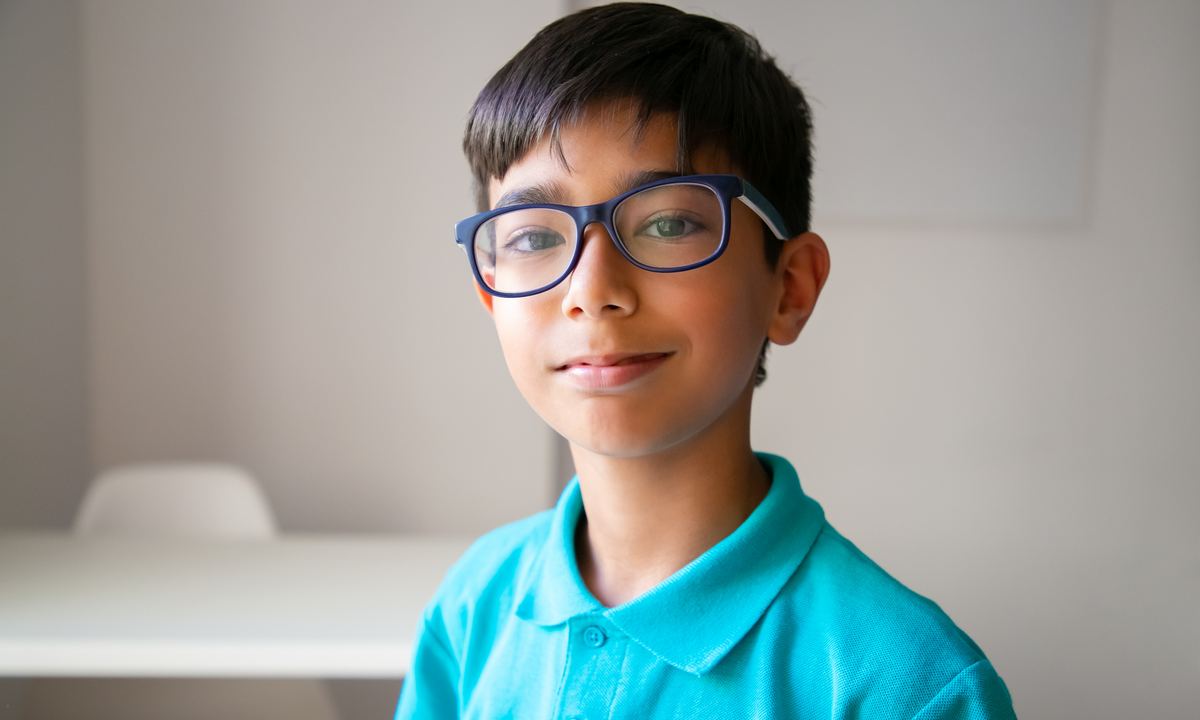 Smiling boy in blue glasses, wearing Kids Fusion lenses